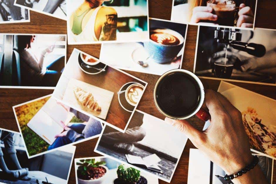 Person Holding Mug Beside Photos